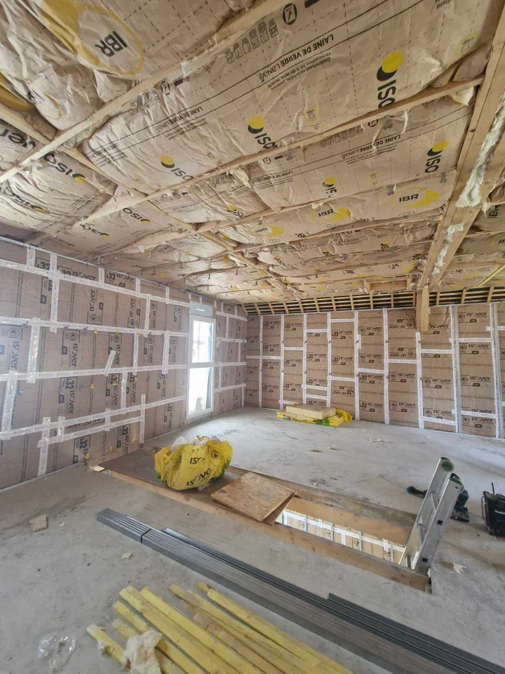 Isolant et ossature de doublage autour d’une ouverture dans le plancher, chantier en cours