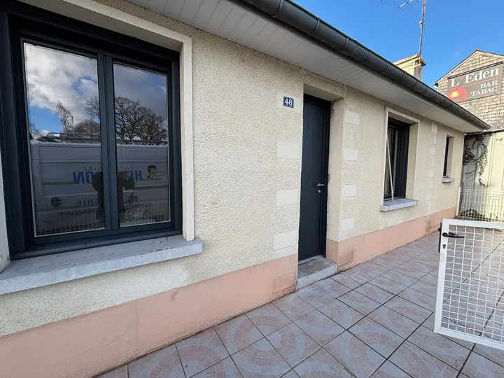 Fenêtre et porte d’entrée sombres dans une façade de maison claire