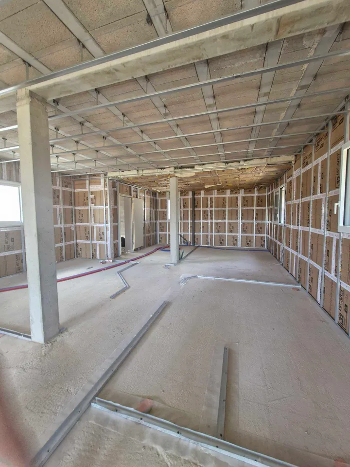 Ossatures métalliques de cloisons et plafond délimitant une circulation sur un chantier