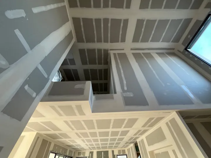 Plaques de plâtre et bandes de joints visibles sur un plafond et ses raccords