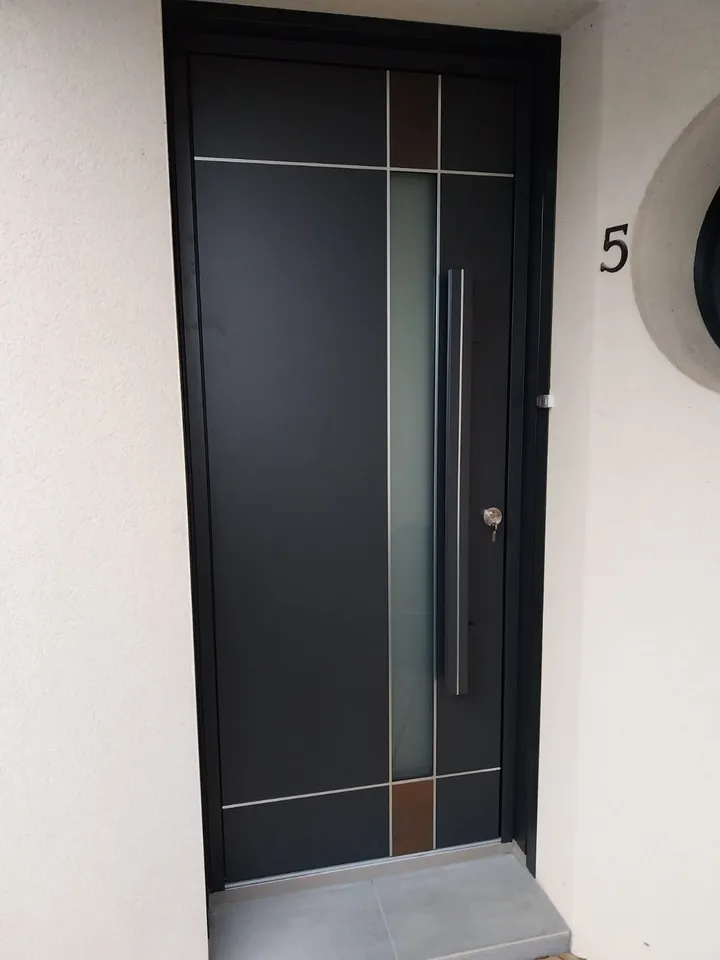 Porte d’entrée gris foncé avec inserts verticaux, posée à Gosné