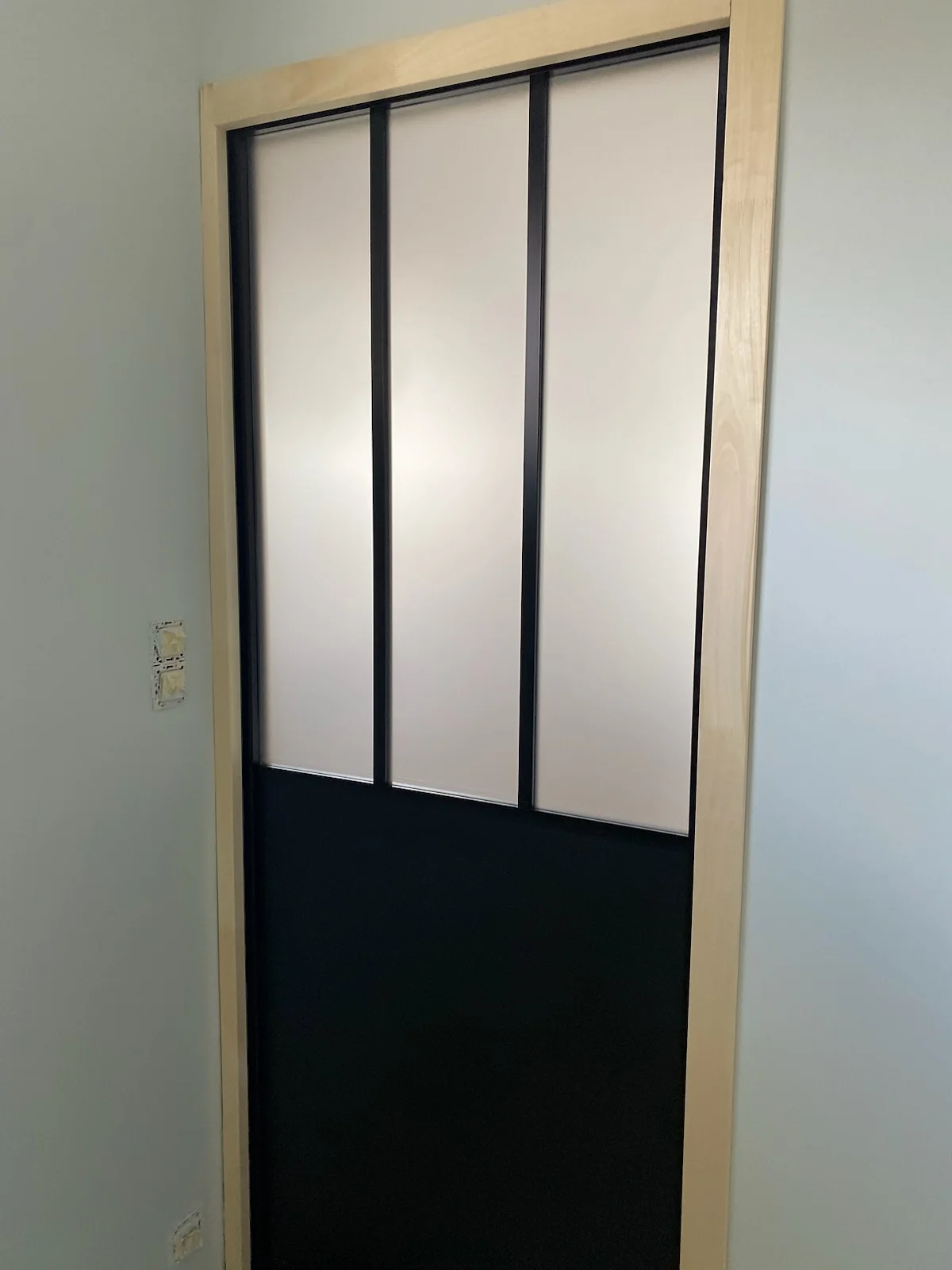 Porte intérieure noire avec panneaux vitrés translucides
