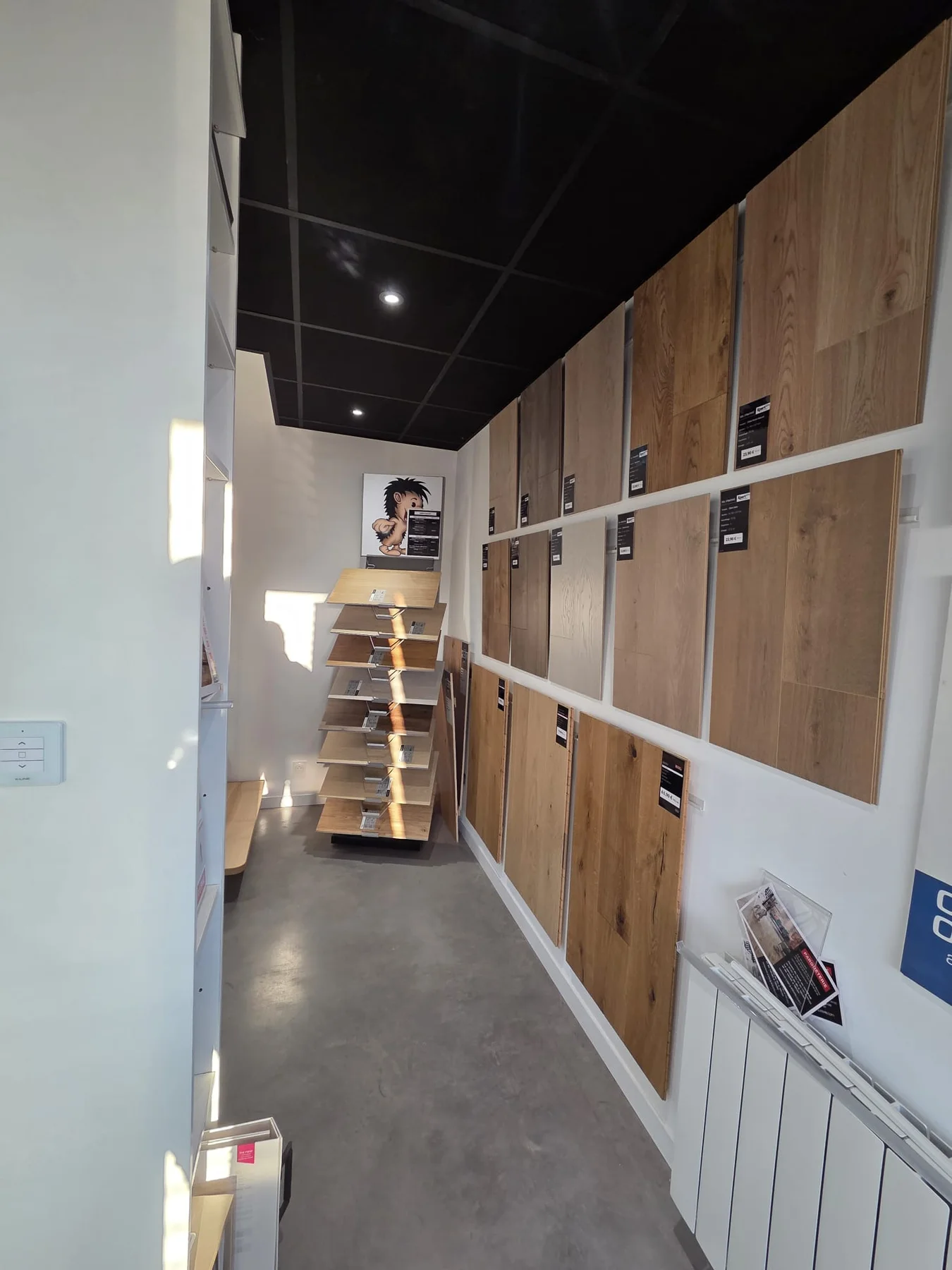 Échantillons de finitions aspect bois présentés sur un mur du showroom