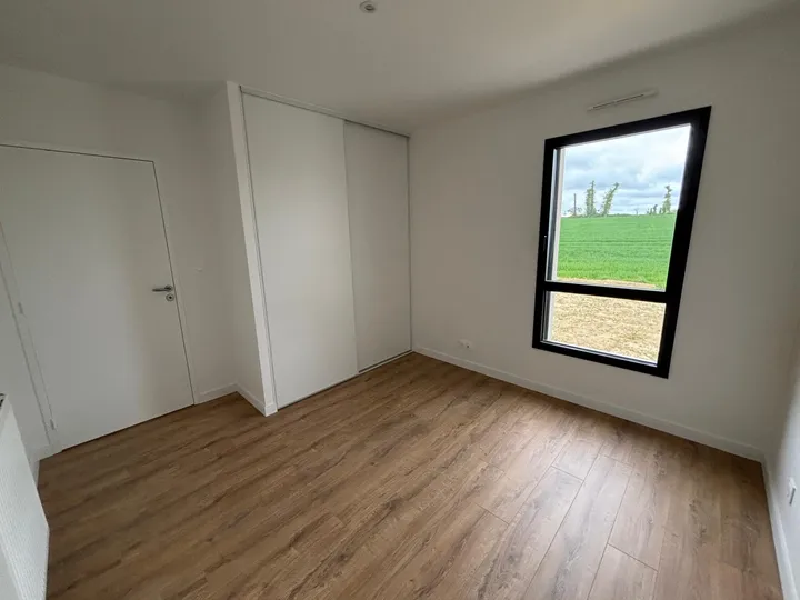 Revêtement de sol aspect bois dans une chambre claire avec placard et fenêtre