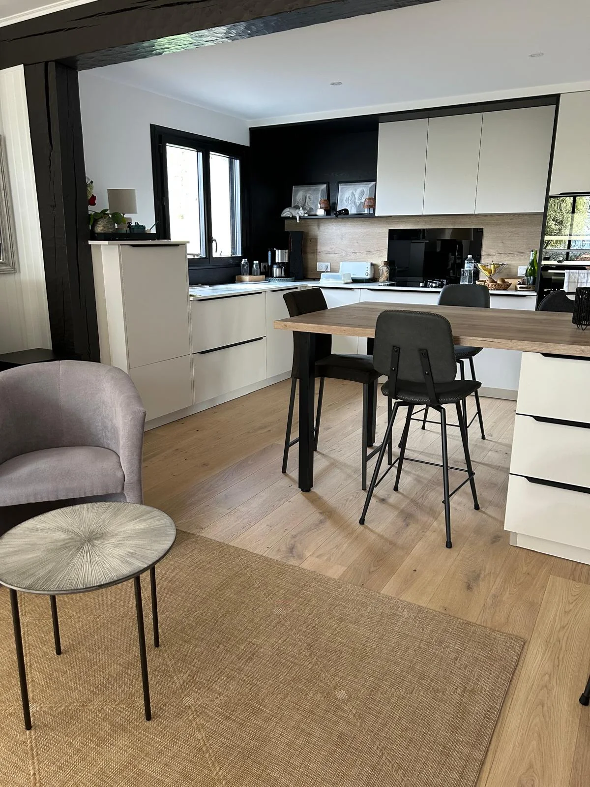 Sol aspect bois clair continu entre un séjour et une cuisine ouverte