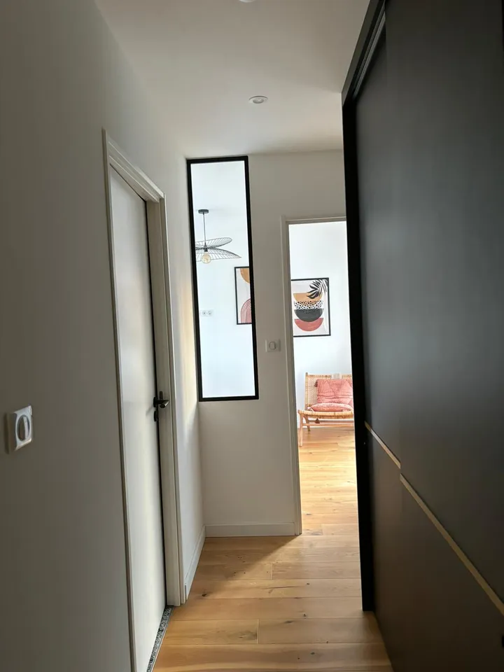 Séparation vitrée verticale à cadre sombre le long d’un passage intérieur